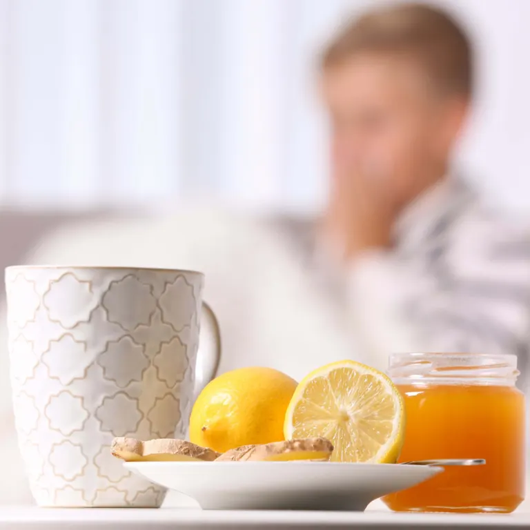 Enfant enrhumé en arrière-plan, tasse, citron et pot de miel