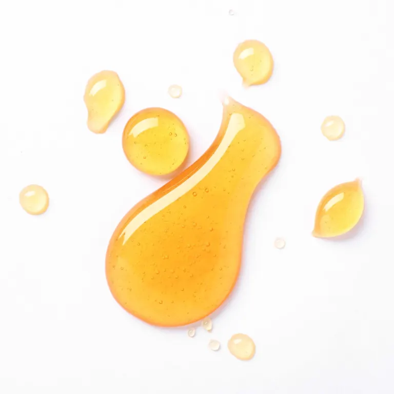 Drops of golden honey on a white background