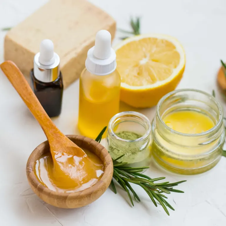 Homemade honey skincare: bowl of honey, oils, lemon, rosemary and soap